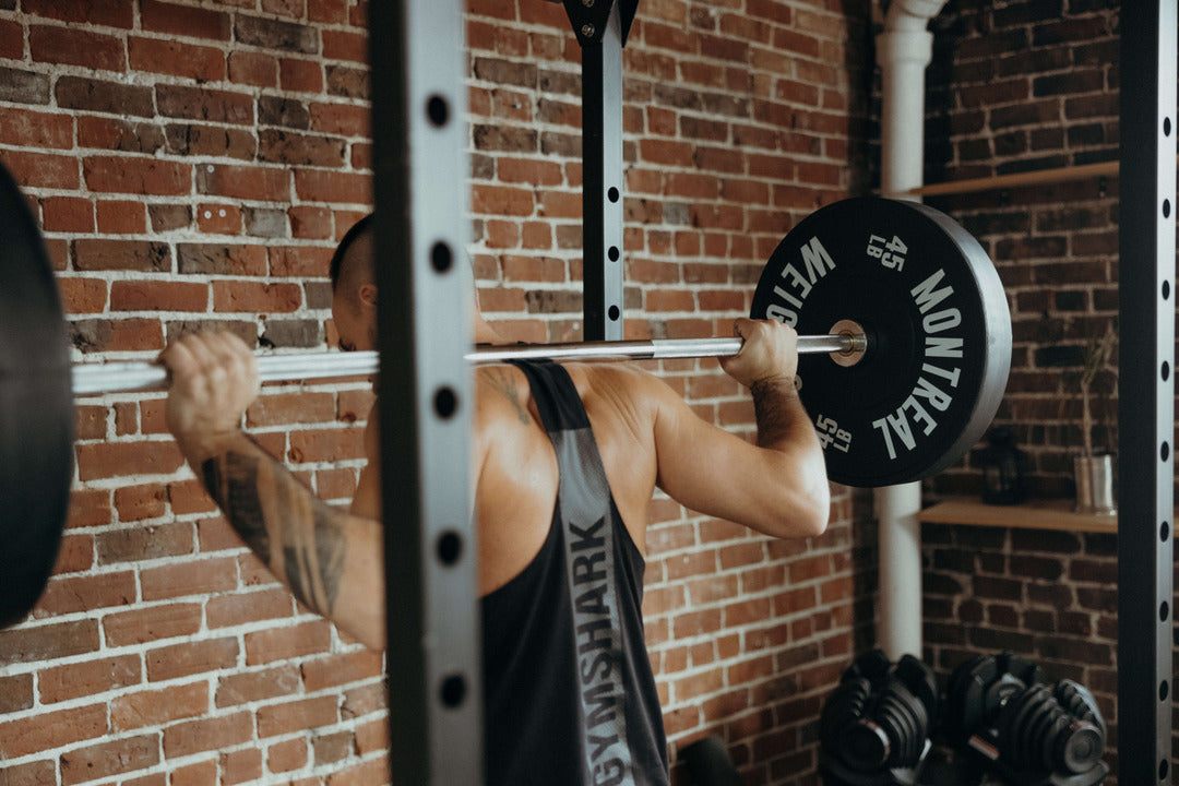man squatting with barbell