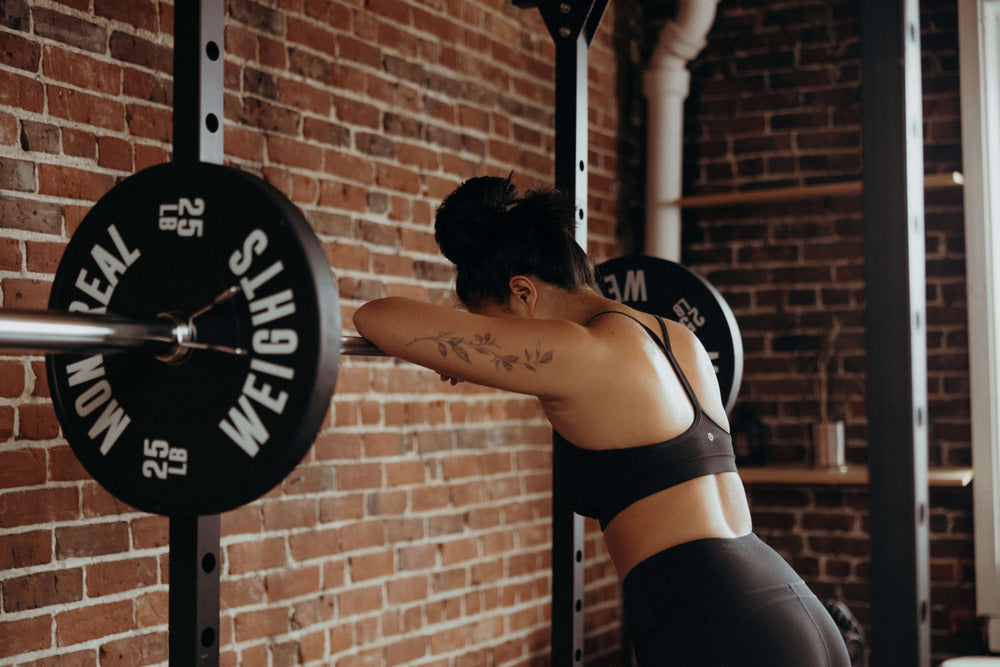 woman leaning on squat rack